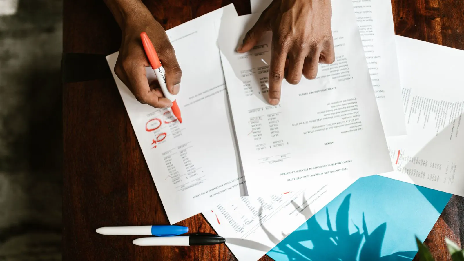 Stack of financial reports and audit sheets on a steel table