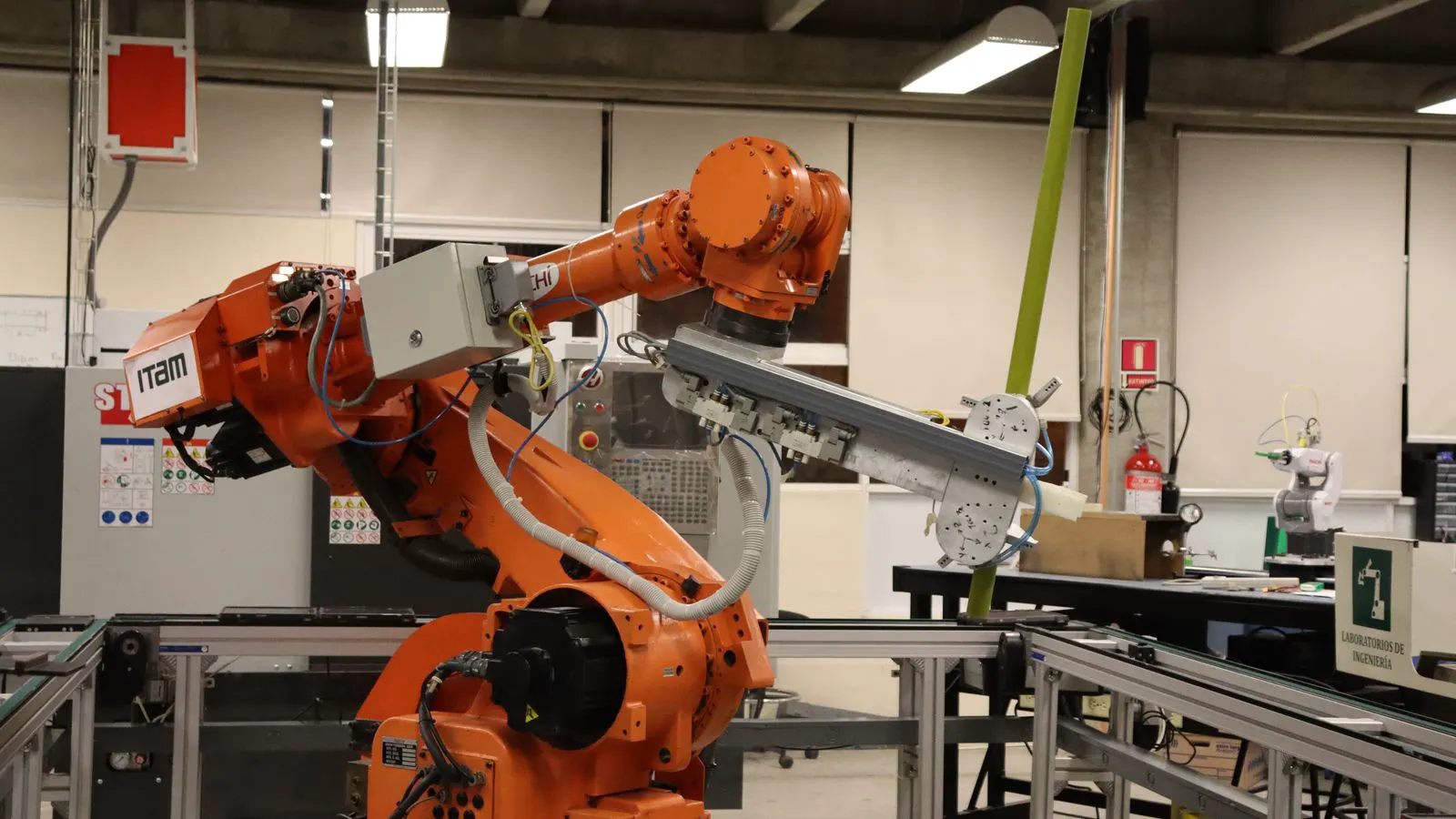 Industrial robot arm positioned near a heavy forging press in a factory.