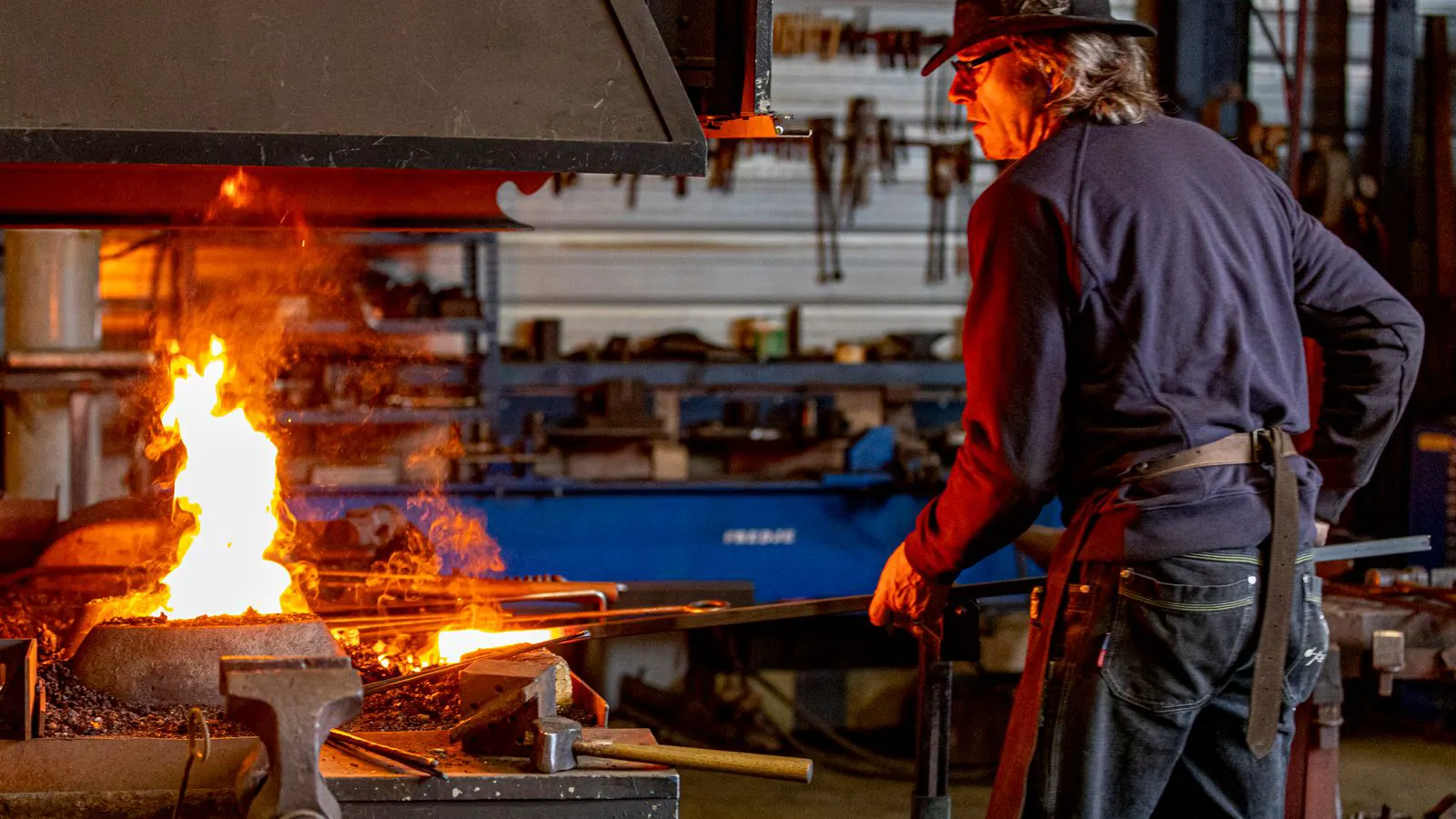 Hammer striking hot metal in a forging shop