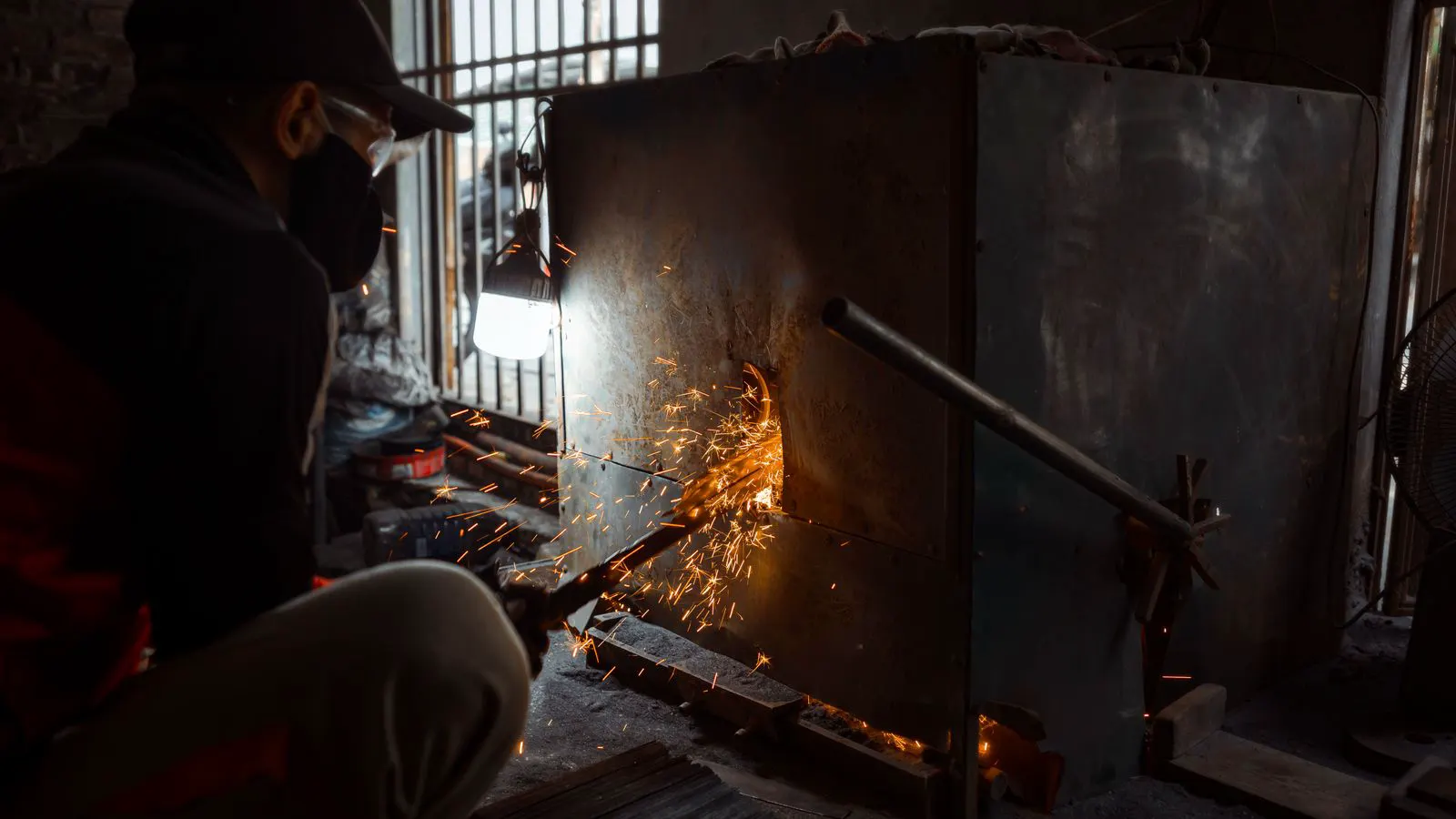 A large industrial furnace adjacent to a quenching tank in a metal shop.