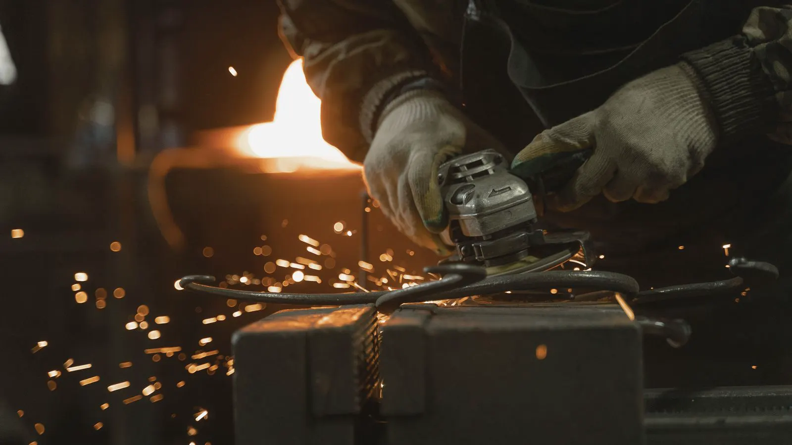 A large mechanical press forming metal in a busy industrial workshop.
